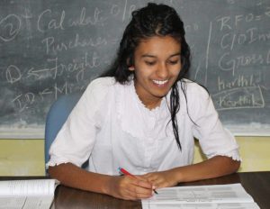 Thanu smiling at desk