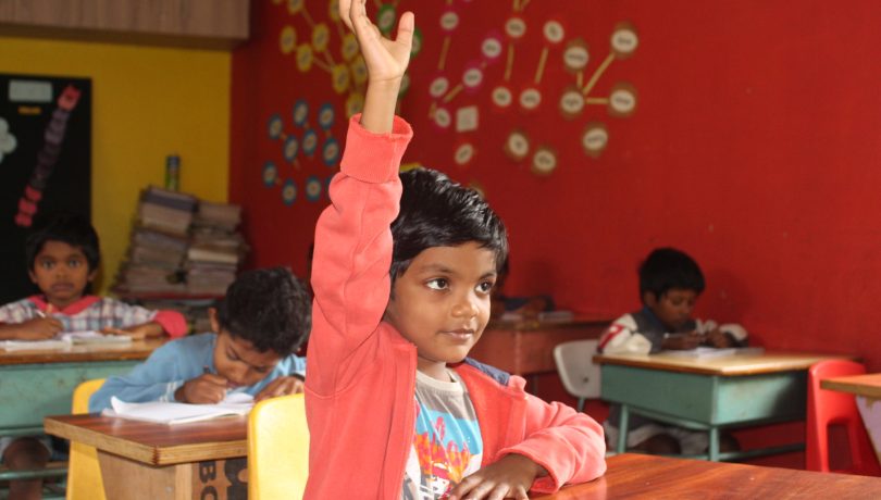 Student raising their hand in class