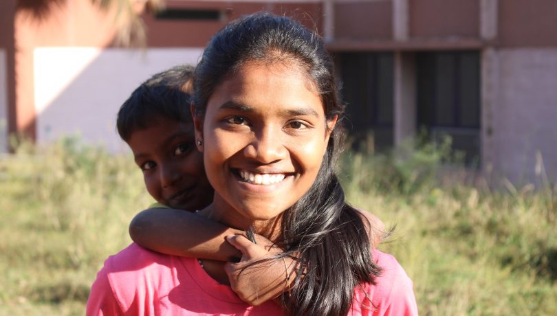 woman smiling while boy hugs her