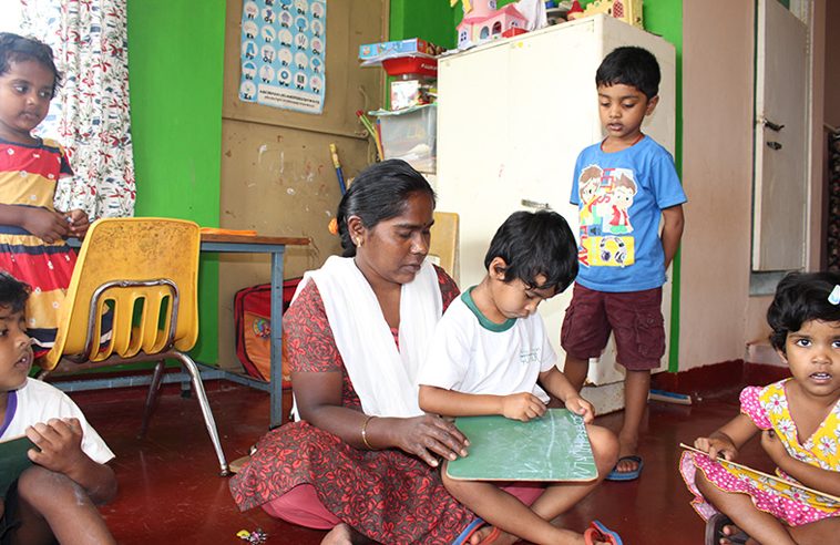 Spirit of Shanti Bhavan - an aunty helps a student with his work