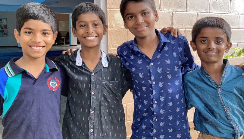 Four boys smiling at the camera