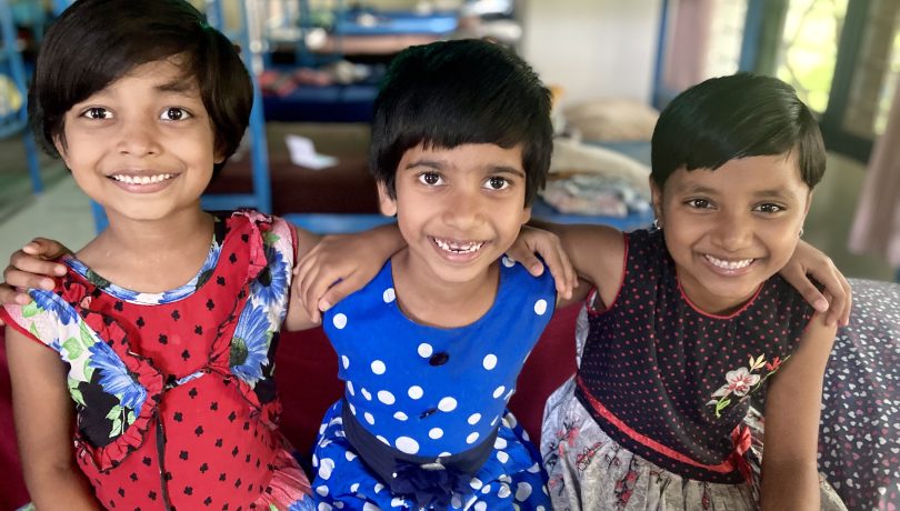 Three girls smile at the camera