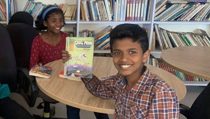 Ashwin V. in the library with classmates