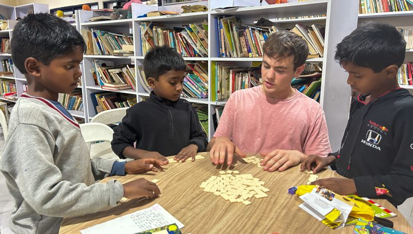 Volunteer playing dominoes with children