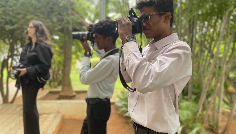 Media volunteer at Shanti Bhavan conducting a photography workshop with high school students