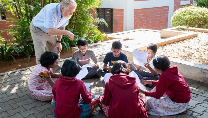 Older volunteer teaching children